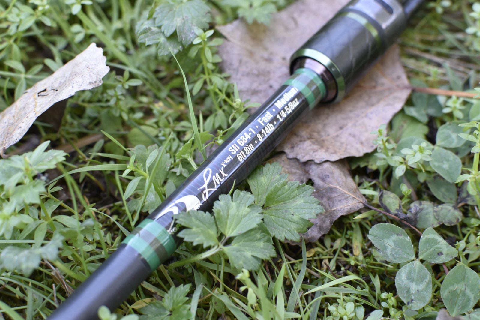 Canne à pêche adaptée à une technique spécifique posée dans l'herbe
